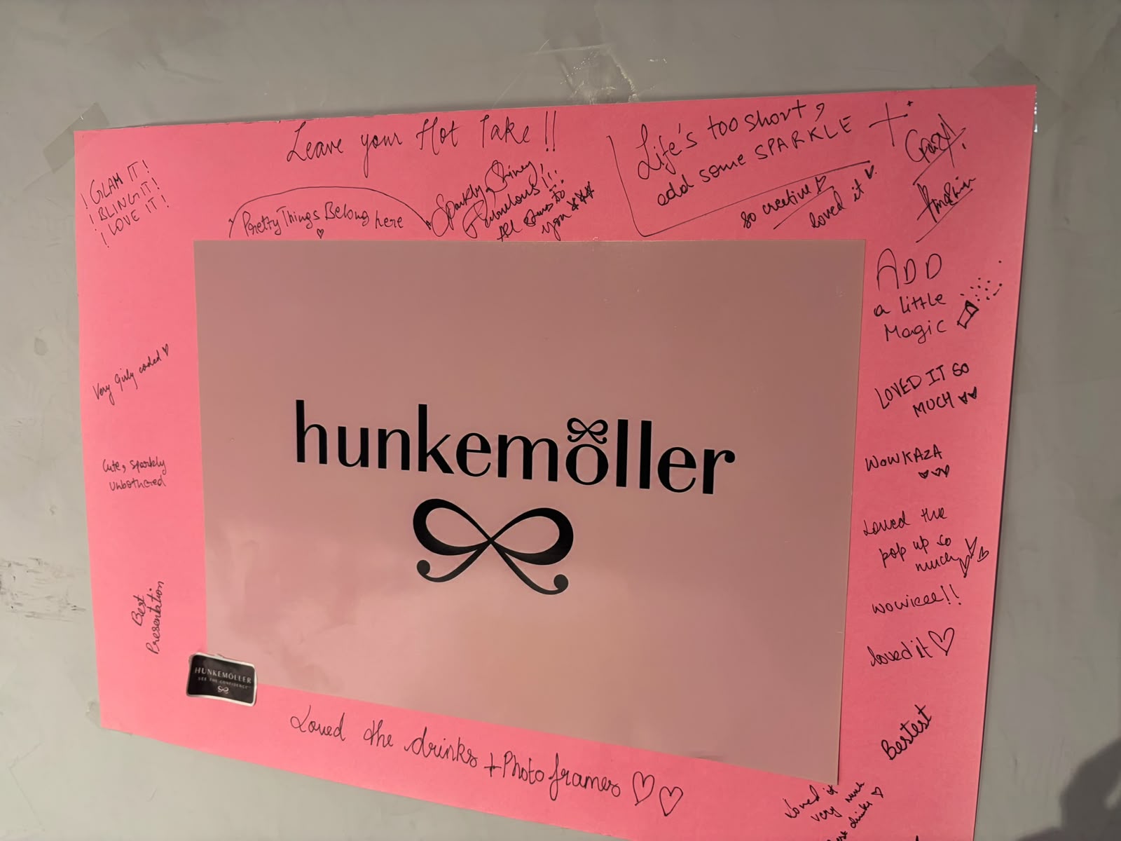 A pink Hunkemöller photo-frame board covered in handwritten guest notes from the activation.